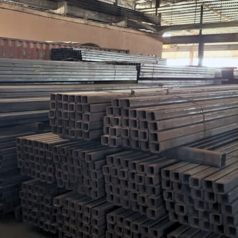 Steel tubes stacked in an industrial warehouse.
